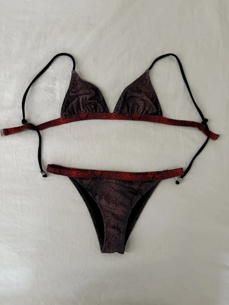 Bikini estampada con diseño de serpiente en tonos violetas  y naranjas. Breteles finos negro. Ideal para lucir en la playa o la pileta con mucho estilo.