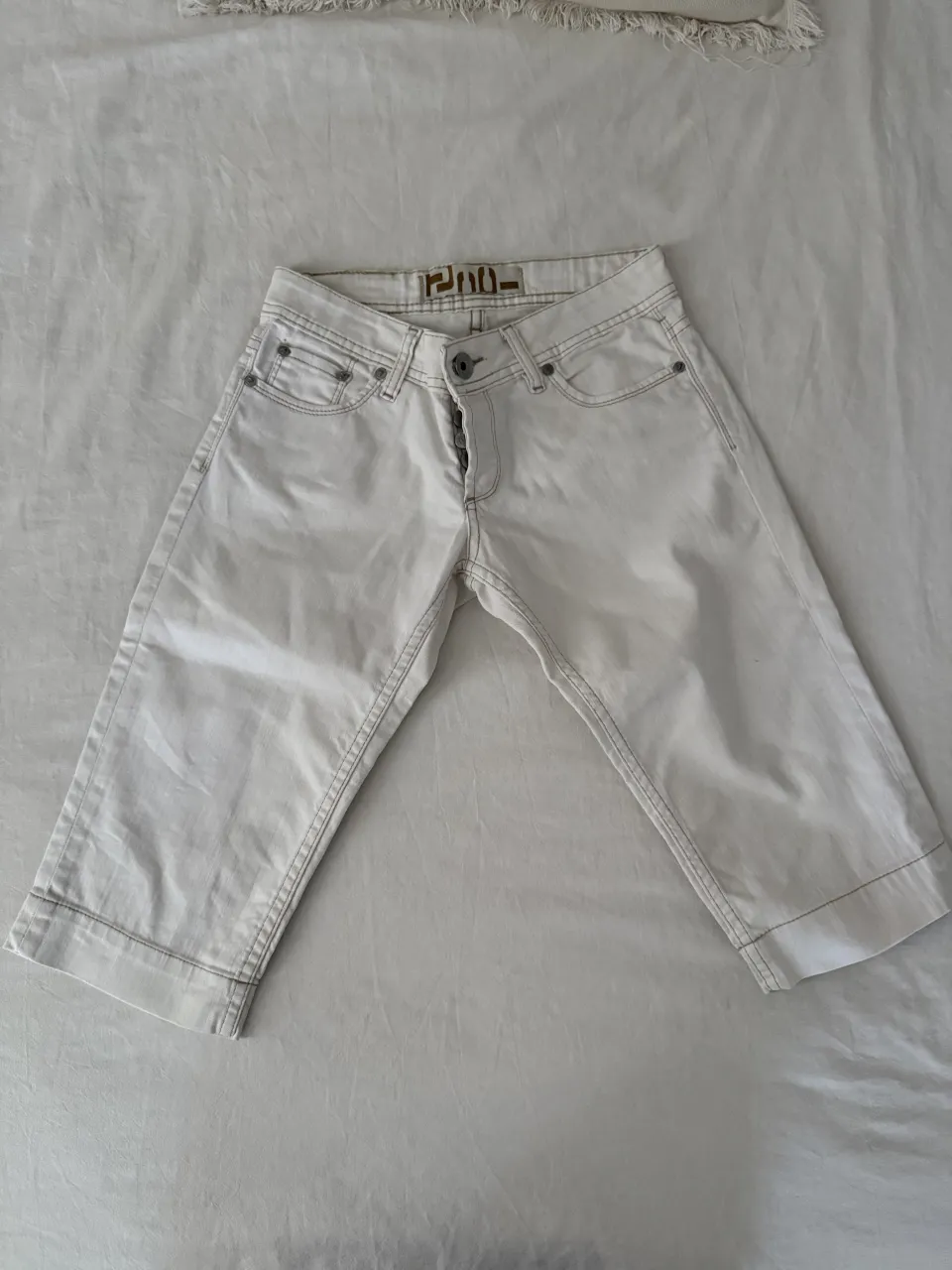 Bermudas blancos con bordados marrones en los bolsillos traseros. Un clásico para el verano, súper cómodos y con un toque chic.
Tiene una mancha en un bolsillo trasera, una linea negra