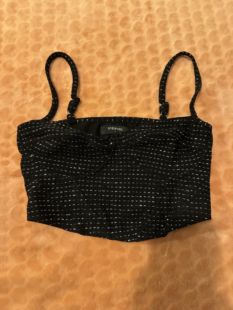 Top negro con detalles plateados.