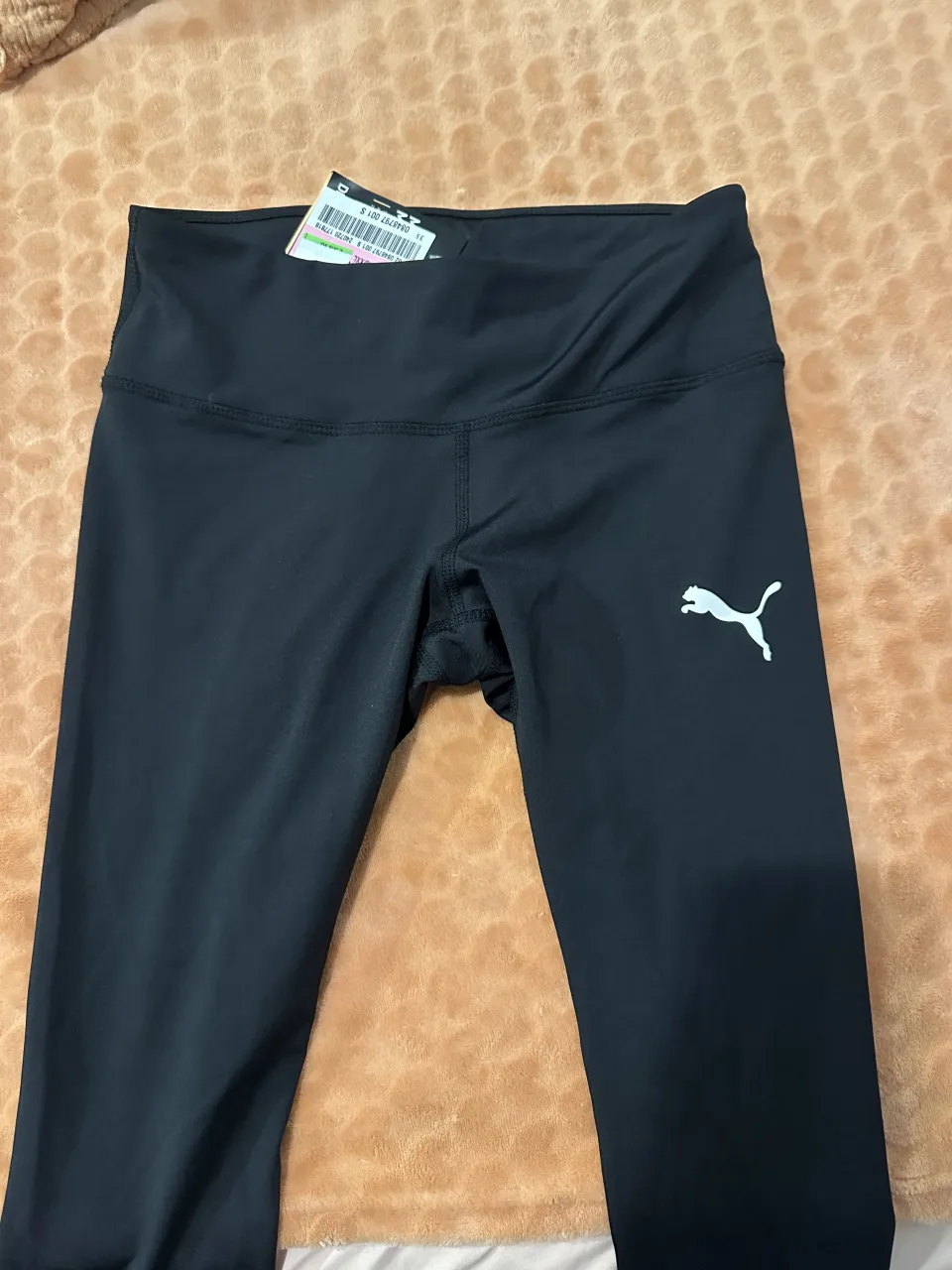 Calzas deportivas negras con logo de Puma blanco en la pierna izquierda. Tienen etiqueta.