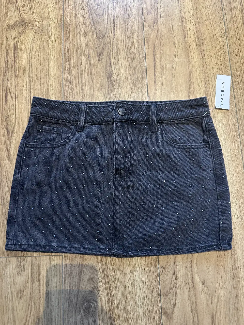 Minifalda de jean negra con detalles de strass. Ideal para un look canchero y moderno.