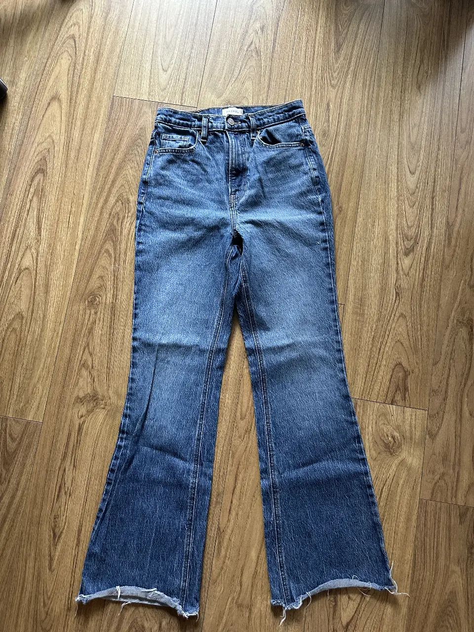 Jeans de mujer, tiro alto, con corte campana y terminación desflecada. Un clásico renovado para un look moderno y canchero.
