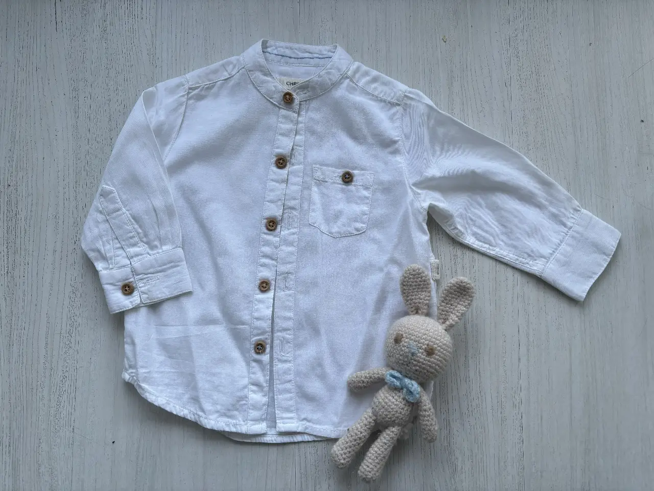 Camisa blanca de manga larga para niño, con cuello mao y botones de madera. Ideal para un look casual y cómodo. (No incluye conejito)