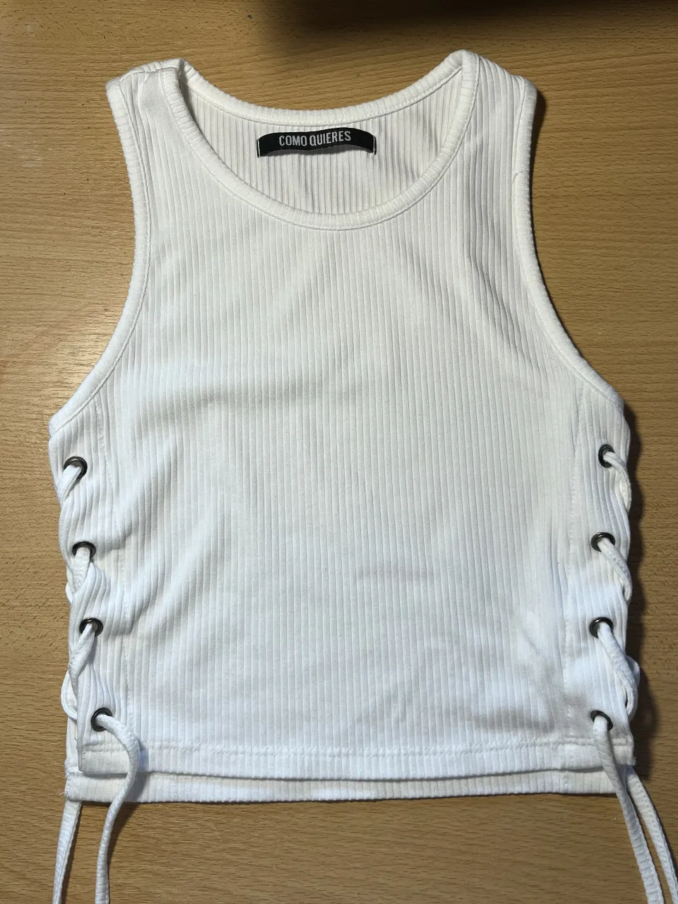 Musculosa blanca con detalles de cordones en los laterales. Ideal para un look casual y canchero.