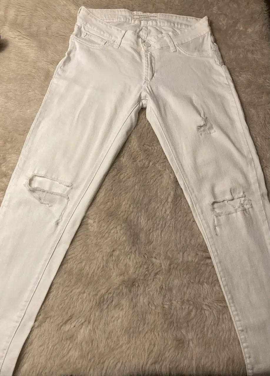 Jean blanco con roturas en las rodillas, tiro medio, usado pero en buen estado, ideal  para un look casual y moderno. Perfectos para combinar con cualquier outfit.