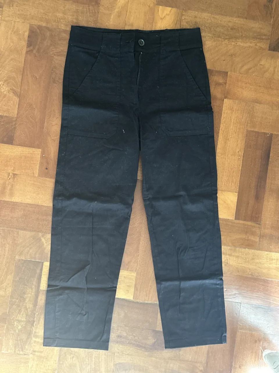 Pantalón negro de vestir con bolsillos delanteros y traseros.