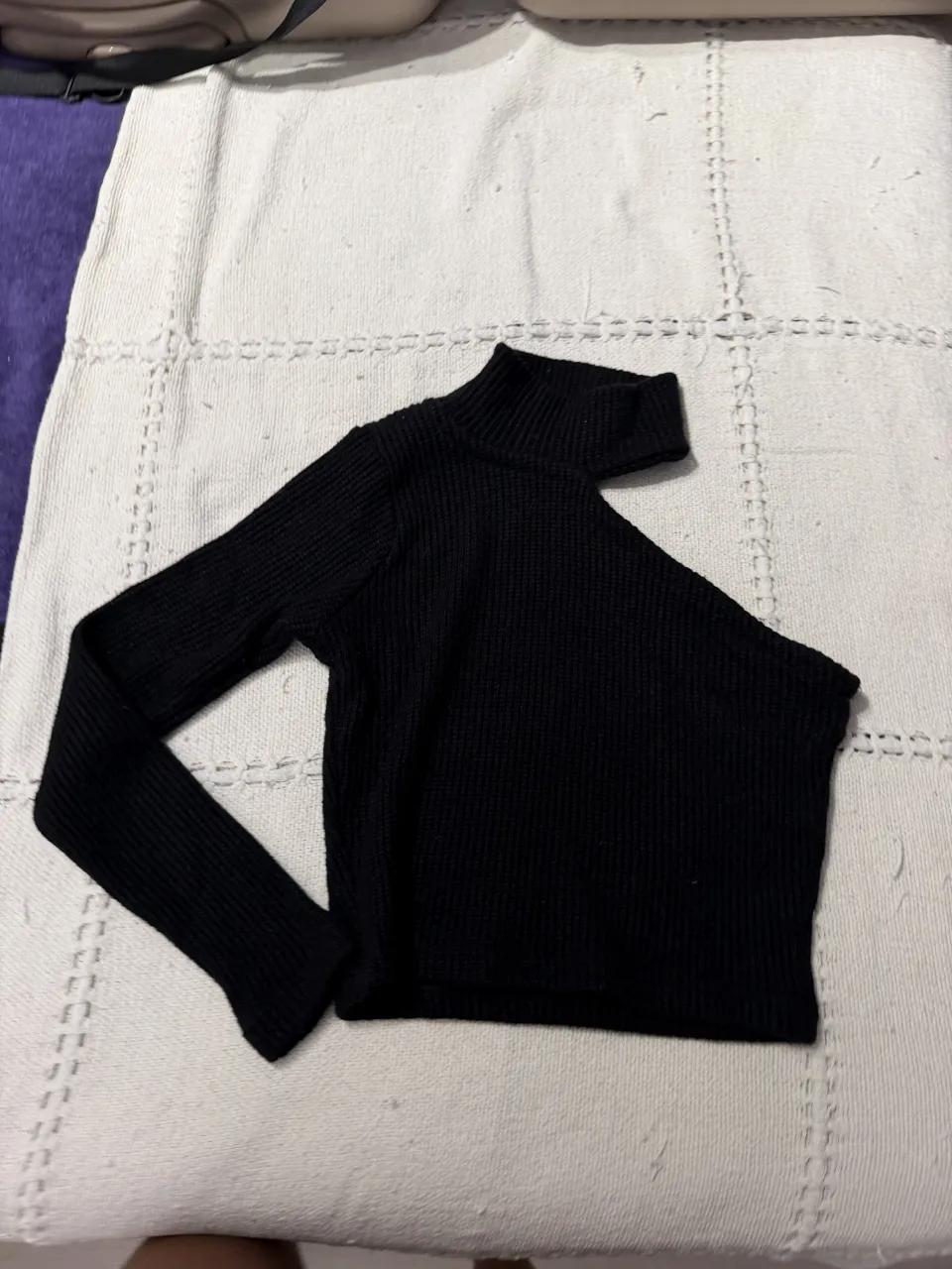 Remera negra de cuello alto, manga larga y corte crop. Ideal para un look canchero y moderno.