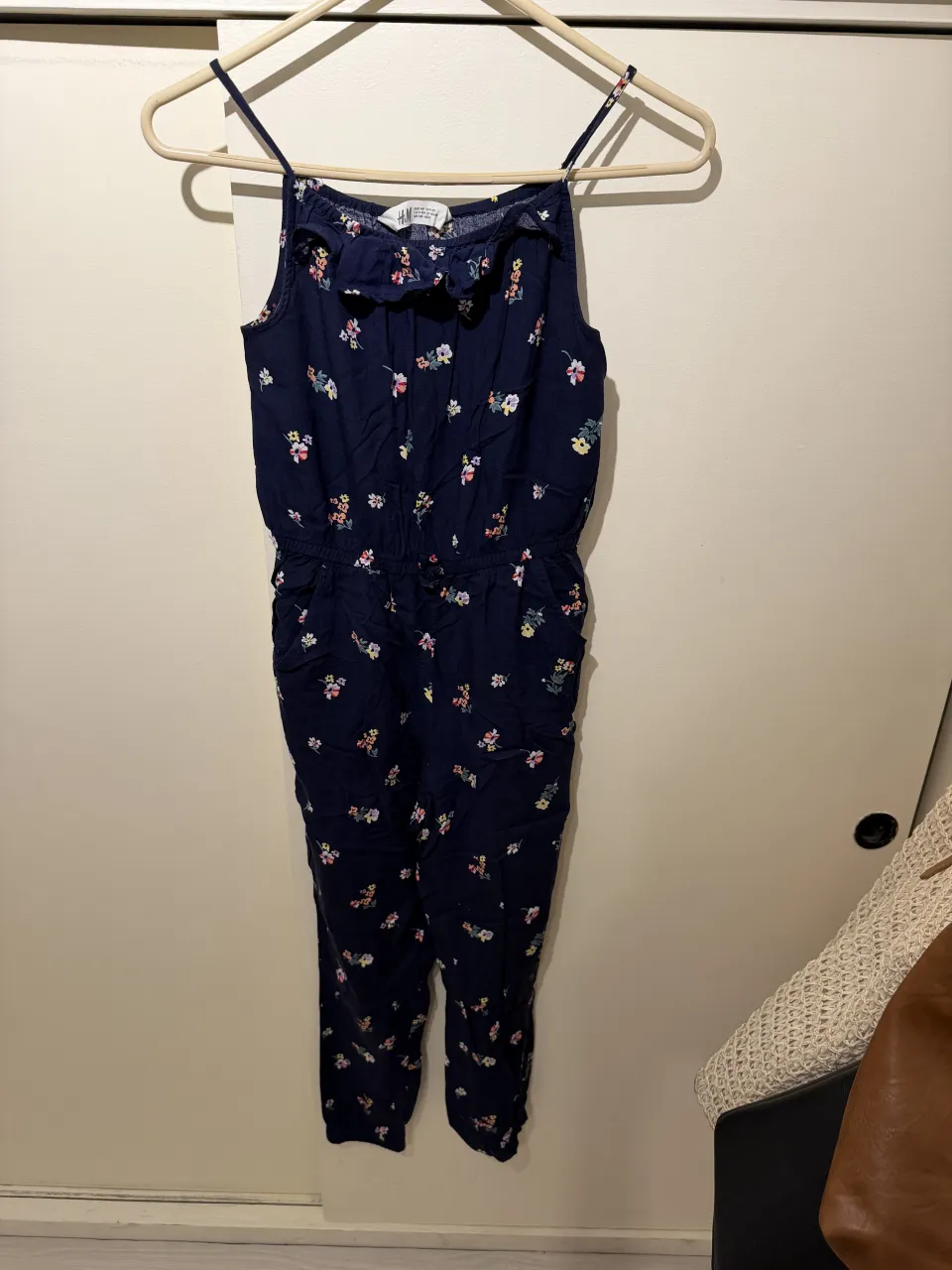 Mono largo estampado floral azul con tiras finas y detalle de volados en el escote. Cintura elastizada para un mejor ajuste. Ideal para días de sol y paseos.