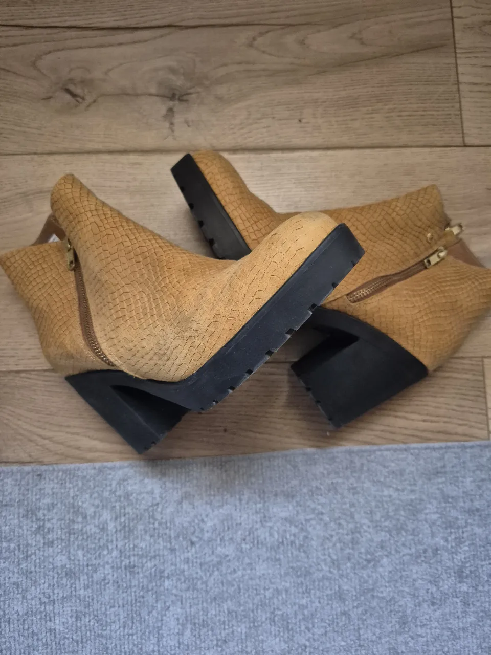 Botines de mujer color marrón claro con textura símil piel de serpiente. Tienen cierre lateral dorado y taco negro. Ideales para un look moderno y canchero.