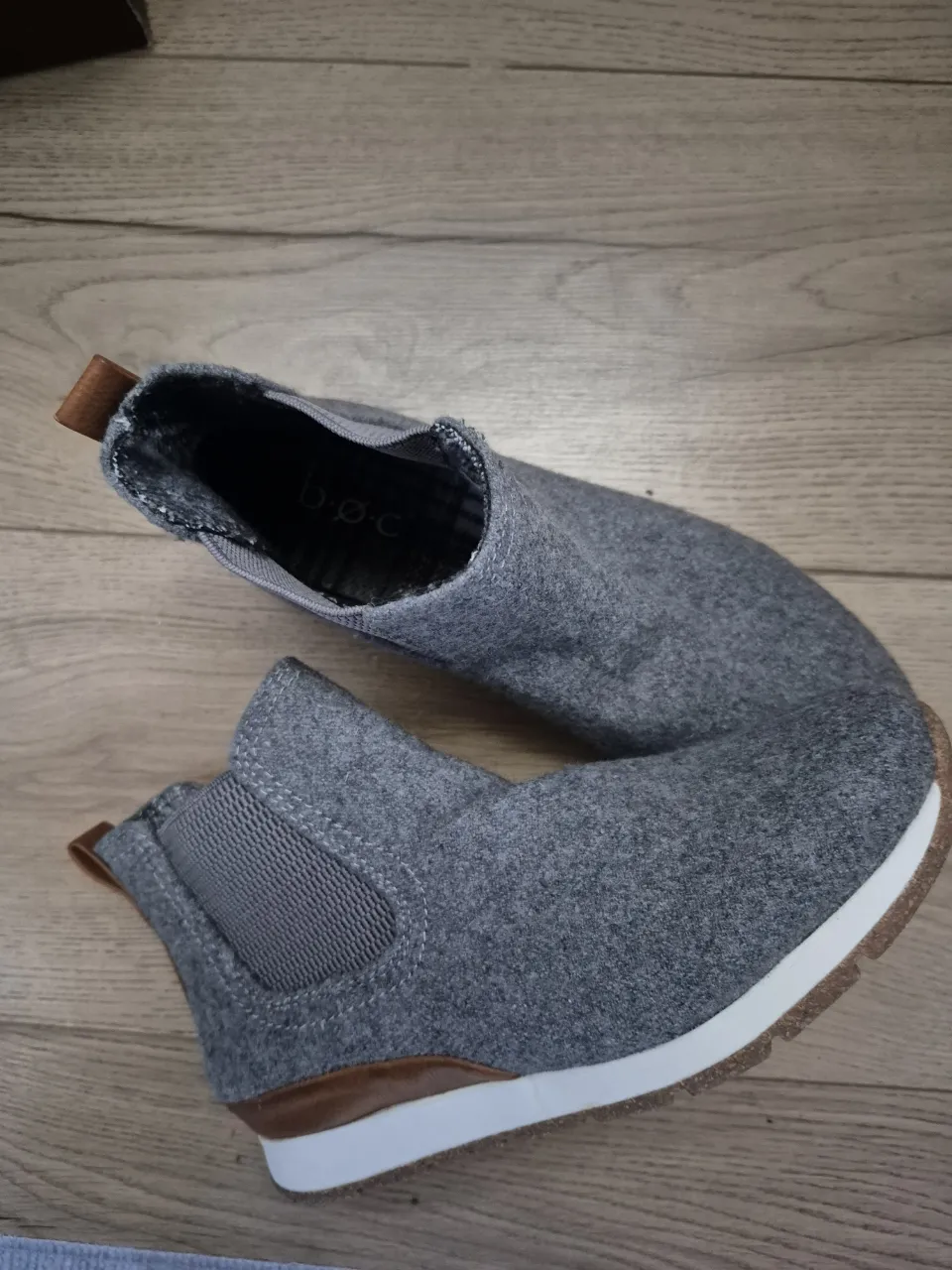 Botines grises de fieltro con detalles en marrón y suela blanca. Ideales para un look casual y cómodo.