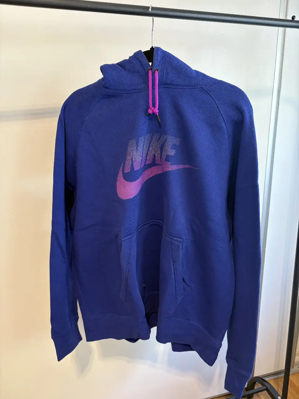 Buzo canguro Nike azul con logo rosa en el frente. Talle XL. Ideal para un look deportivo y casual.