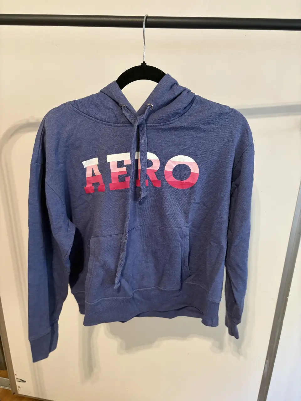 Buzo canguro Aeropostale azul con estampado "AERO" en rosa y blanco. Talle XL, ideal para un look casual y cómodo.