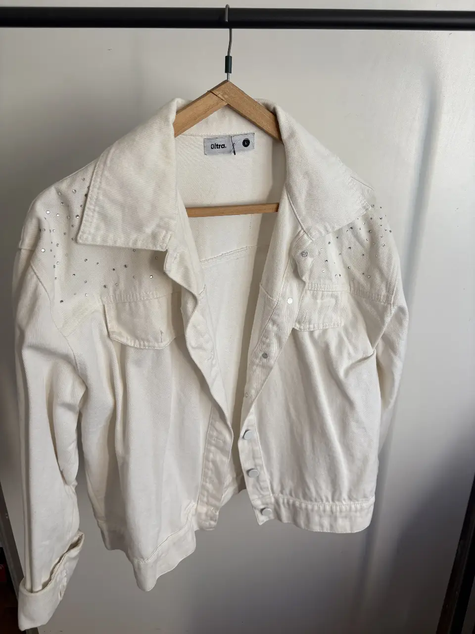 Campera de jean blanca con detalles de strass en los hombros. Talle L de la marca Ultra. Ideal para un look canchero y moderno.