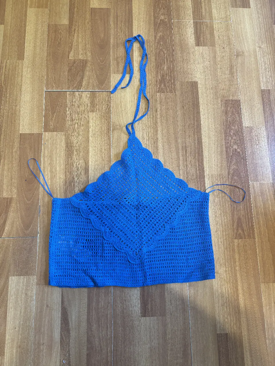 Top tejido a crochet de color azul, con diseño triangular en el frente y tirantes ajustables. Ideal para un look fresco y artesanal.