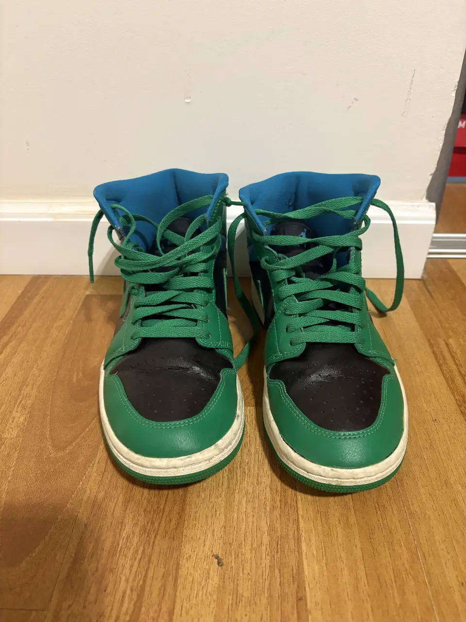 Zapatillas Air Jordan 1 Mid, con detalles en verde y negro, con suela blanca y detalles en azul. Talle 8.5 US.