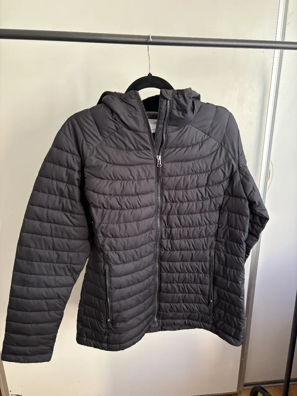 Campera Columbia negra acolchada con capucha, ideal para el invierno. Cuenta con cierre frontal y bolsillos laterales. Talle L.