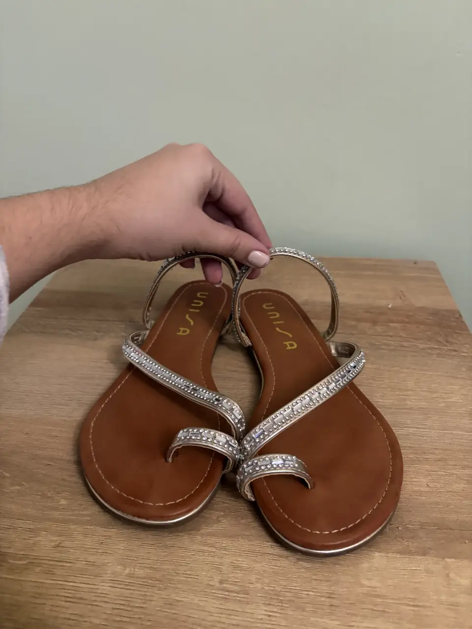 Sandalias planas de mujer, color marrón con detalles plateados y brillantes. Ideales para el verano y ocasiones casuales.