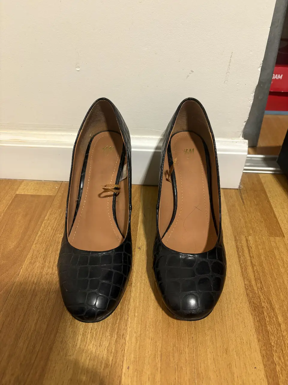 Elegantes zapatos de taco alto negros con diseño de reptil, ideales para eventos formales o salidas nocturnas. Marca H&M.