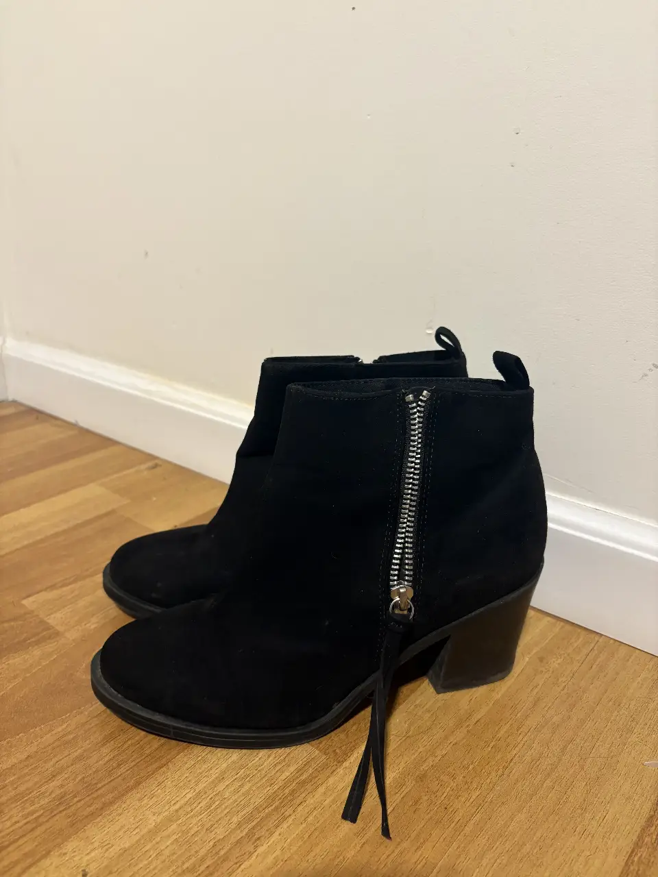 Botines negros de gamuza con cierre lateral y taco ancho. Ideales para un look casual y moderno.