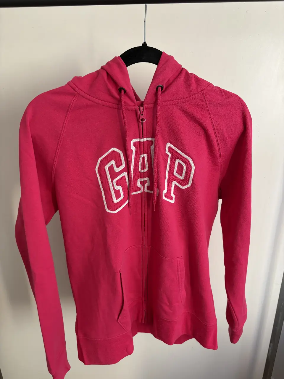 Buzo con cierre de la marca Gap, color rosa, con el logo de la marca en blanco. Talle L.
