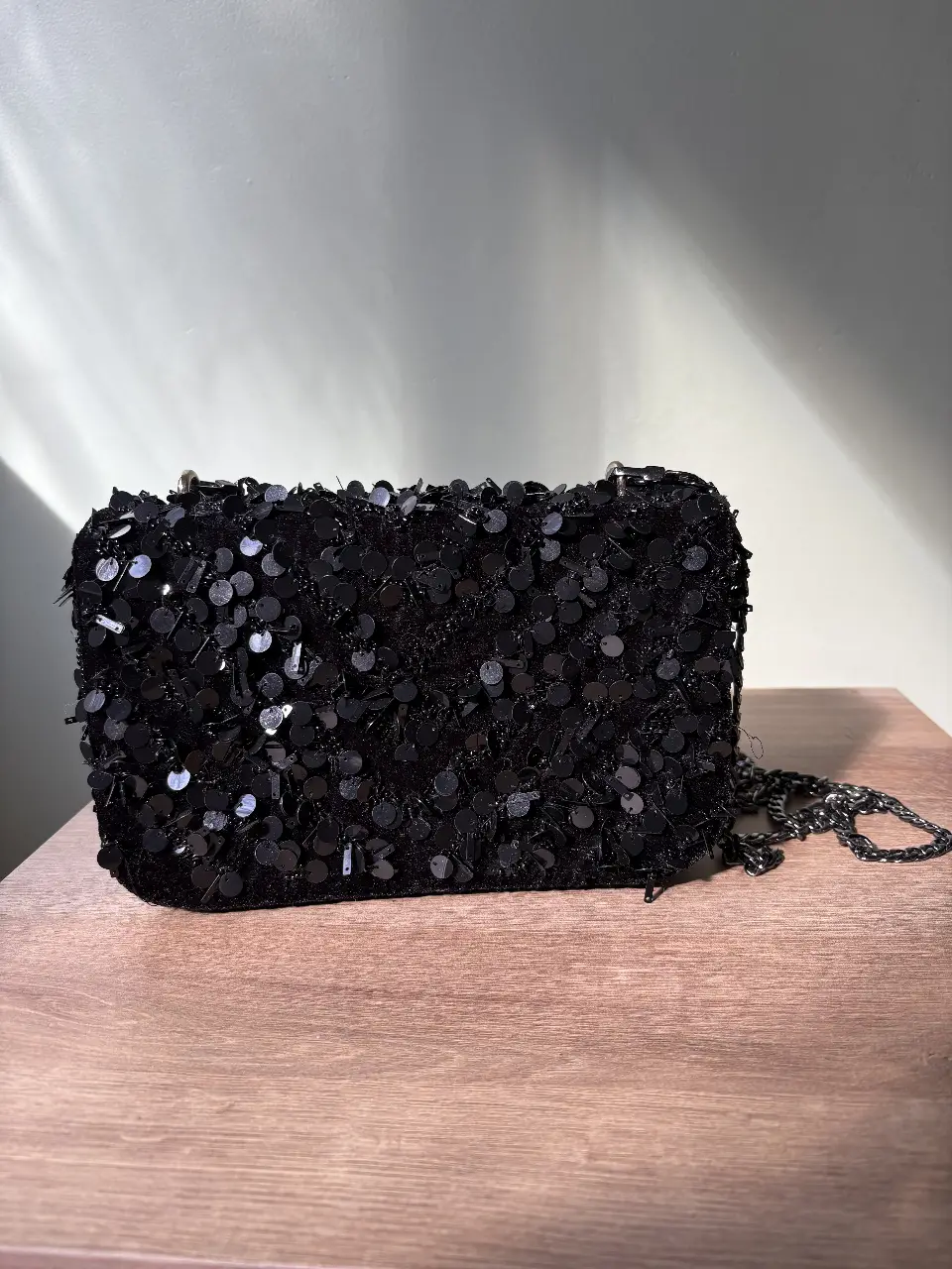 Cartera de mano negra con lentejuelas, ideal para eventos y fiestas. Diseño elegante y sofisticado.