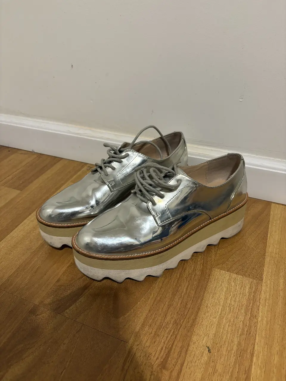 Zapatos Oxford de plataforma con acabado metalizado plateado. Ideales para un look moderno y audaz.