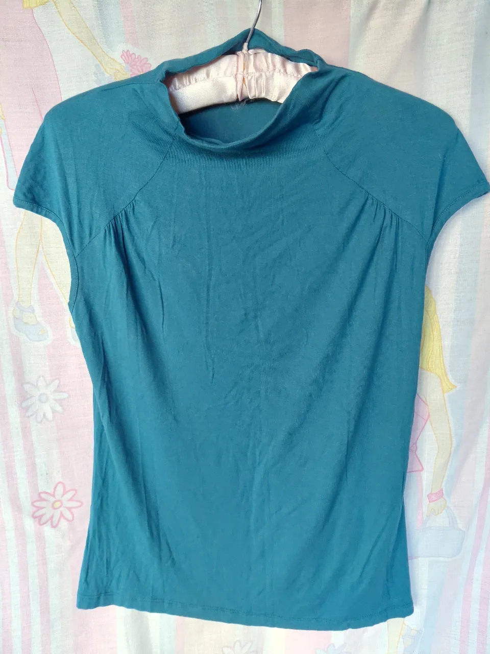 Remera de mujer de manga corta con cuello alto. Talle small, ideal para un look casual y moderno.