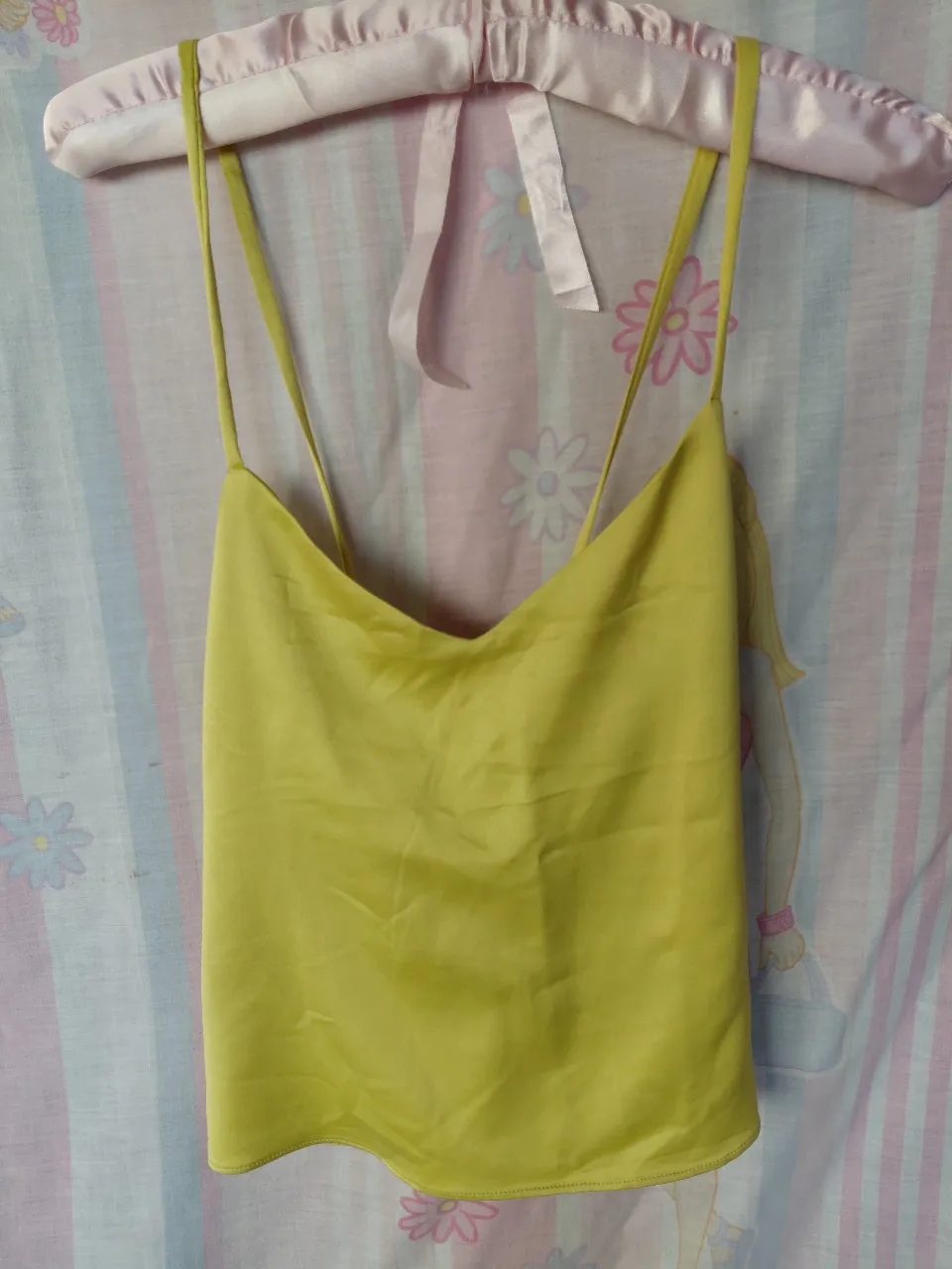 Top de satén amarillo con tiras finas y espalda cruzada. Ideal para un look fresco y elegante.