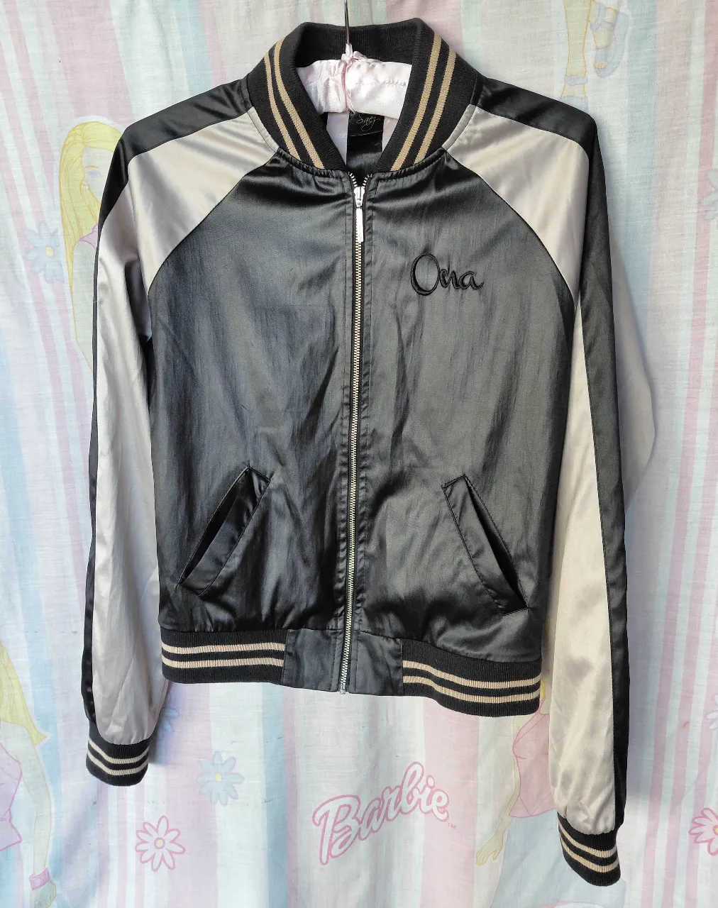 Campera bomber negra y gris Ona Sáez con detalles dorados. Ideal para un look casual y canchero.