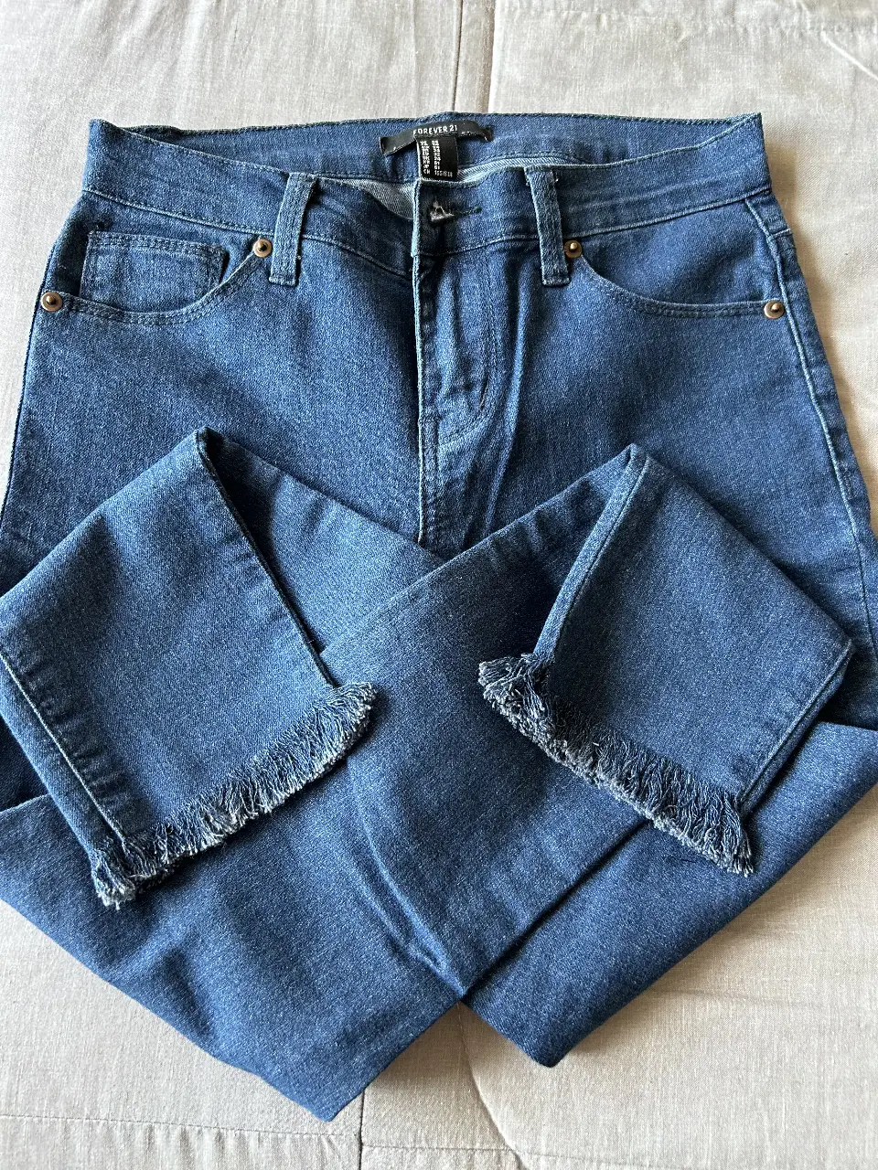 Jeans de mujer Forever 21, tiro medio, con detalle de flecos en el bajo. Un clásico que no puede faltar en tu guardarropa.
