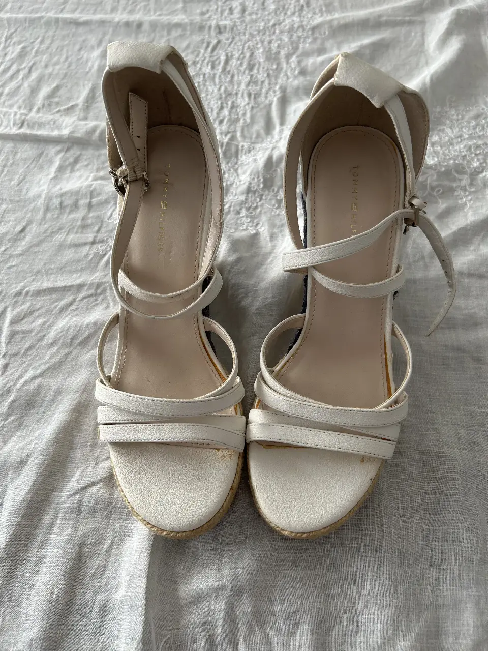Sandalias Tommy Hilfiger blancas con plataforma de yute y detalles en azul. Tiras finas y cierre con hebilla en el tobillo. Ideales para un look de verano.