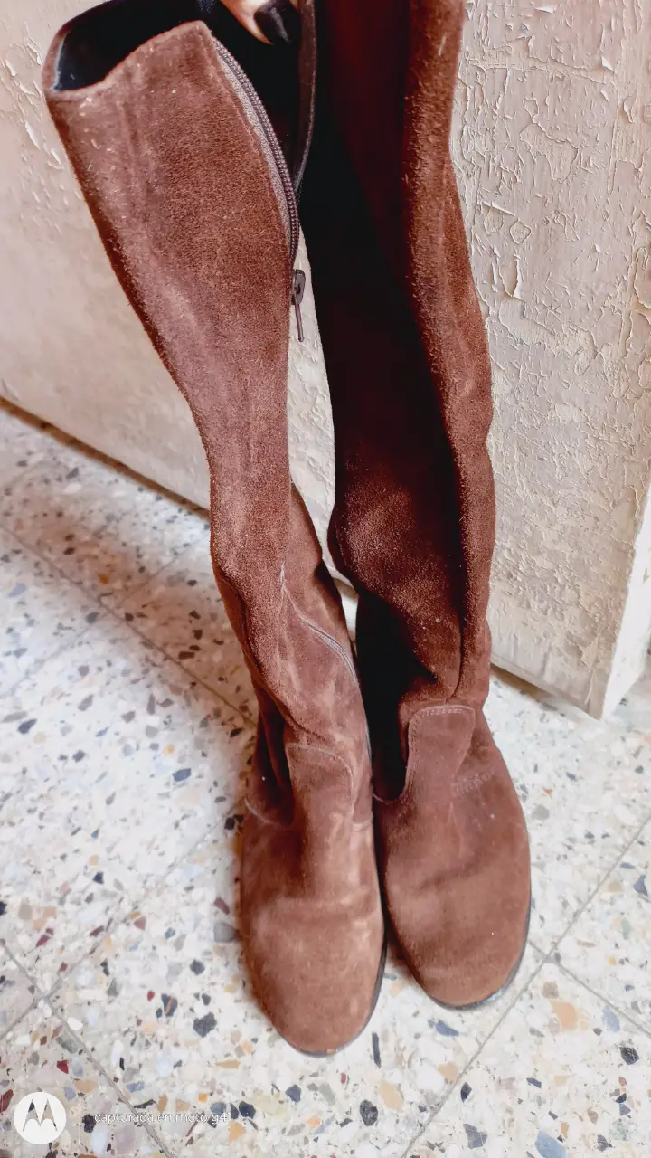 Botas de caña alta de gamuza marrón, con cierre lateral y taco bajo. Ideales para un look casual y abrigado.