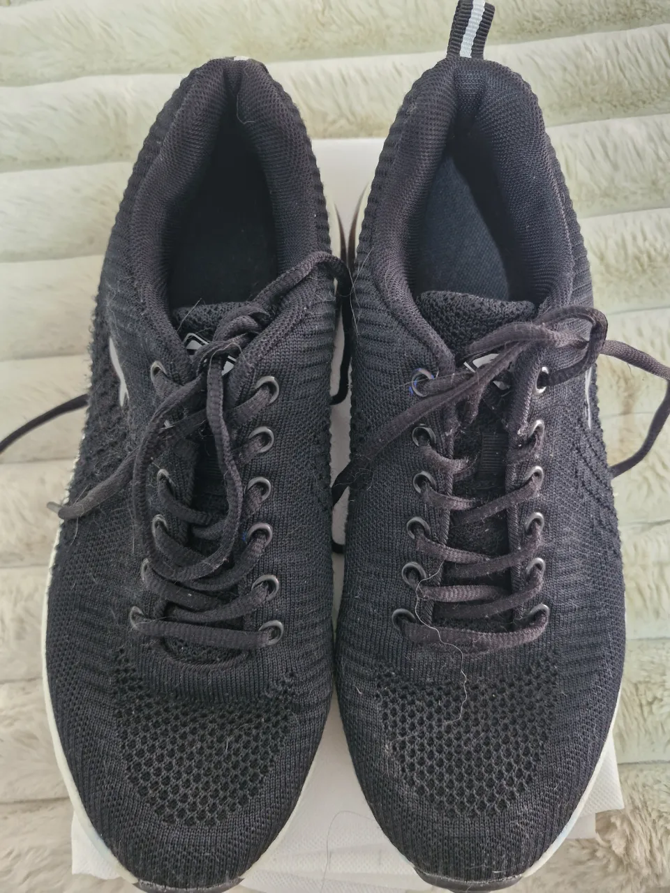 Zapatillas deportivas negras con detalles blancos. Ideales para running y entrenamiento. Diseño moderno y cómodo.