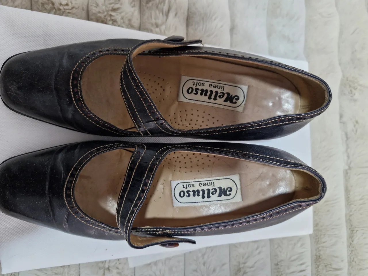 Zapatos Melluso linea soft de cuero negro con detalles en costura. Diseño clásico con tira en el empeine y taco bajo. Ideales para un look vintage y cómodo.