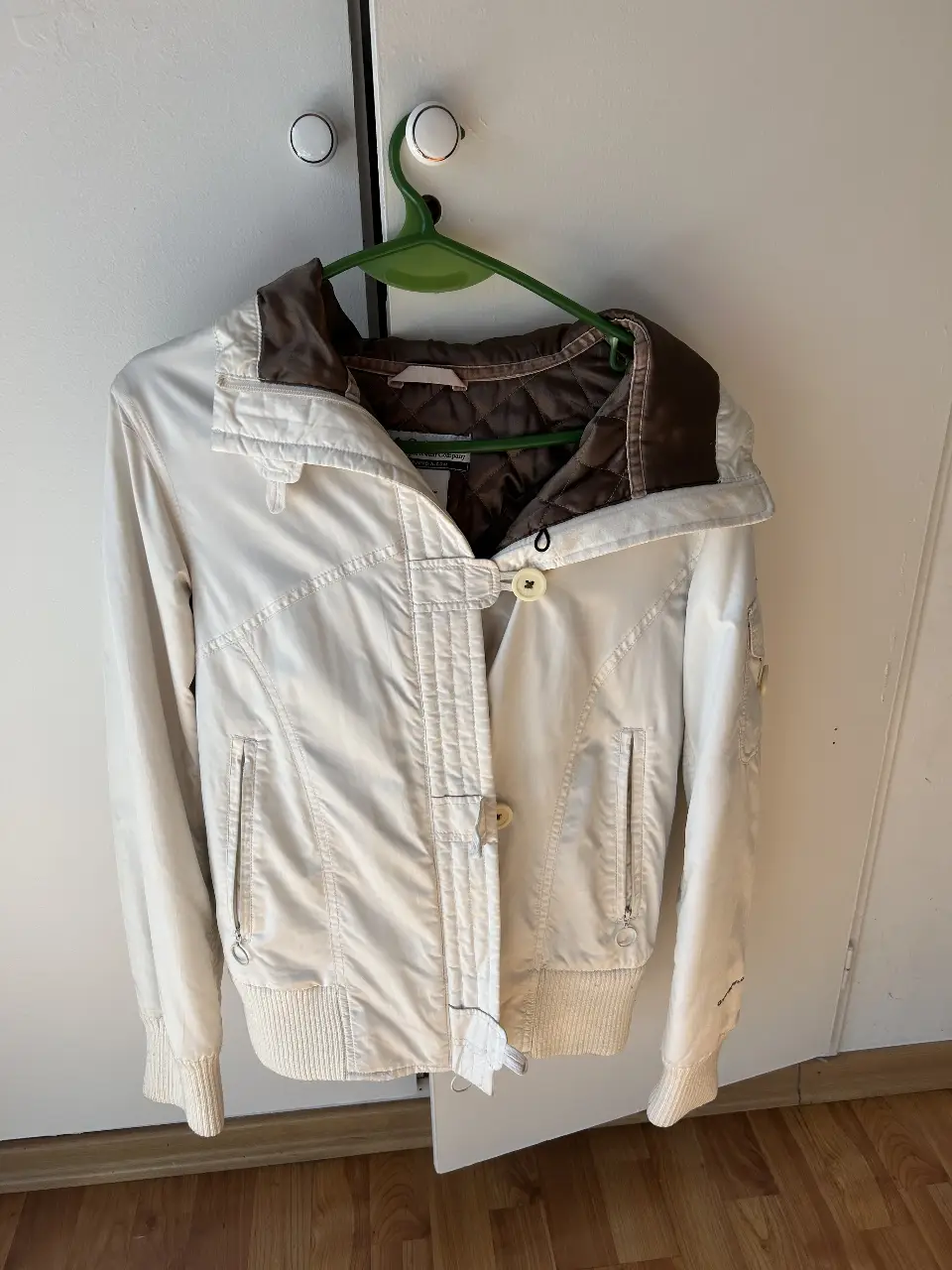 Campera Columbia blanca con detalles marrones, ideal para el invierno. Talle S de mujer, con cierre y bolsillos.