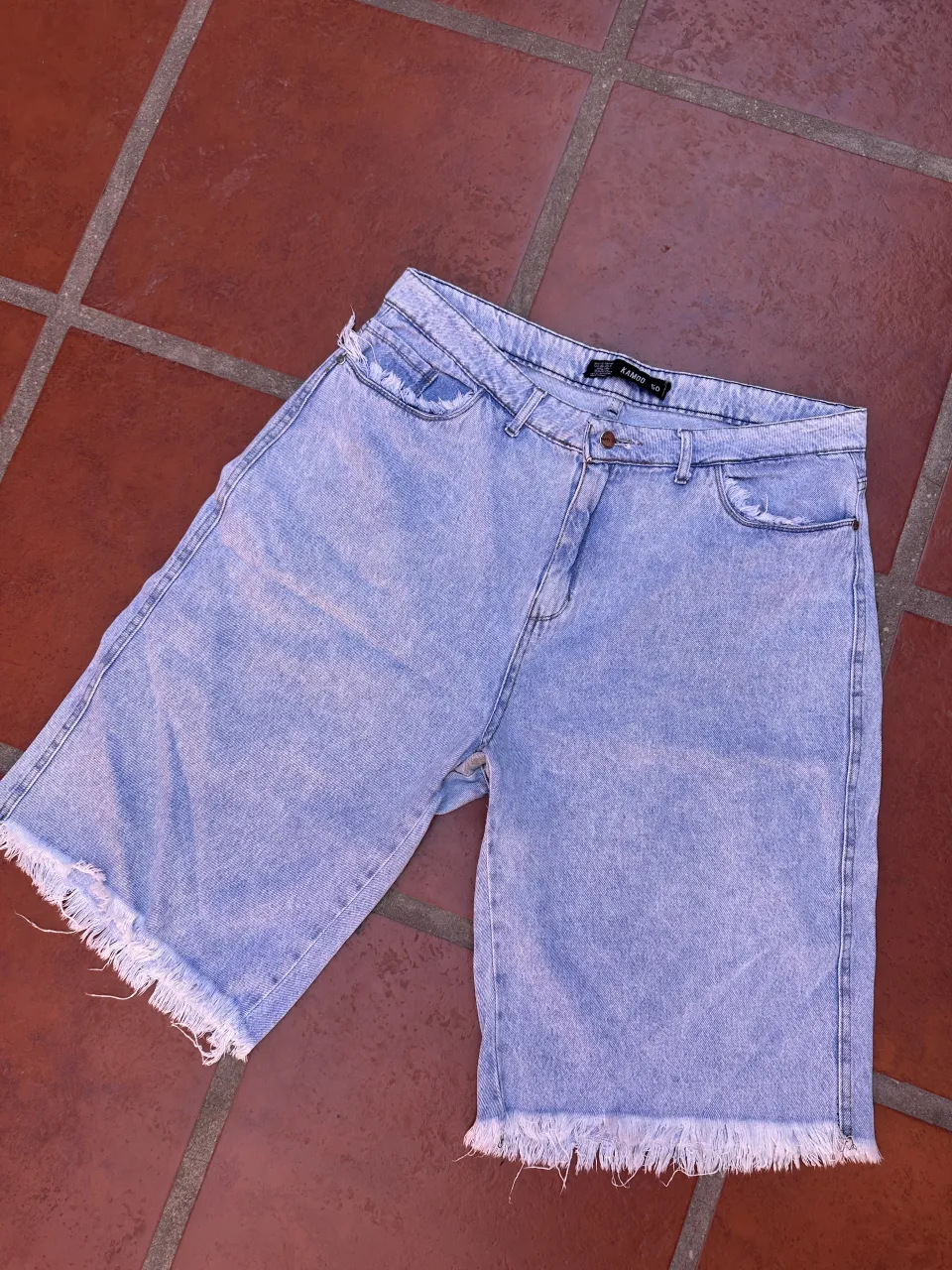 BERMUDAS anchas, con roturas y flecos en los bordes.