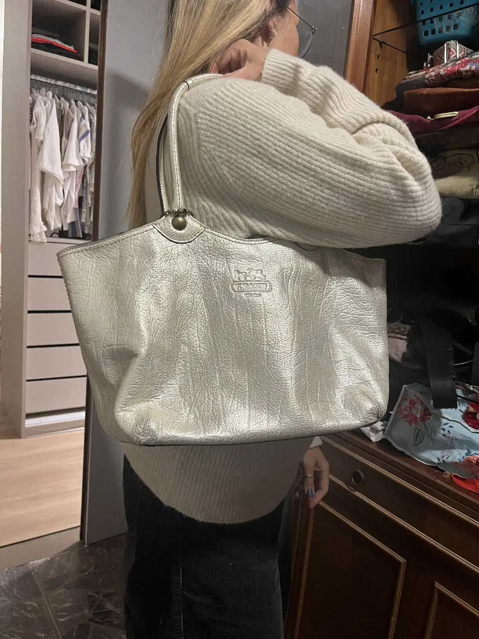 Cartera Coach plateada, ideal para llevar al hombro. Confeccionada en cuero, con un diseño elegante y espacioso. Perfecta para un look sofisticado y funcional.