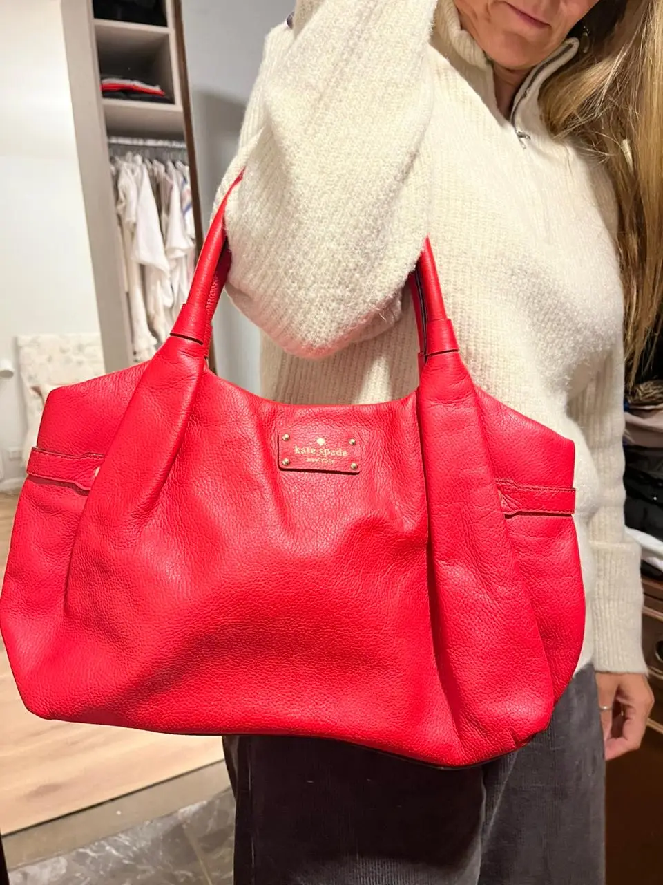 Cartera Kate Spade roja de cuero, con manijas y detalles dorados. Amplia y con cierre interno.