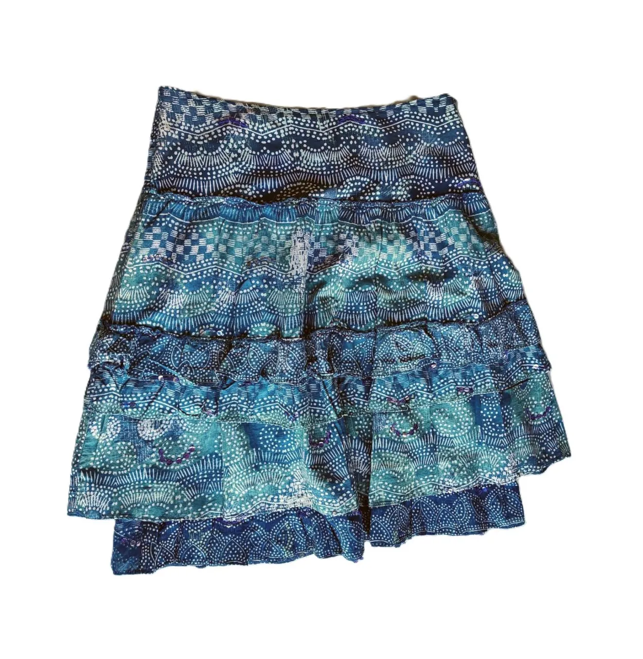 Pollera larga de mujer con diseño estampado en tonos azules y blancos. Confeccionada con tela ligera y fluida, presenta múltiples volados que le dan movimiento y un estilo bohemio. Ideal para un look fresco y veraniego.