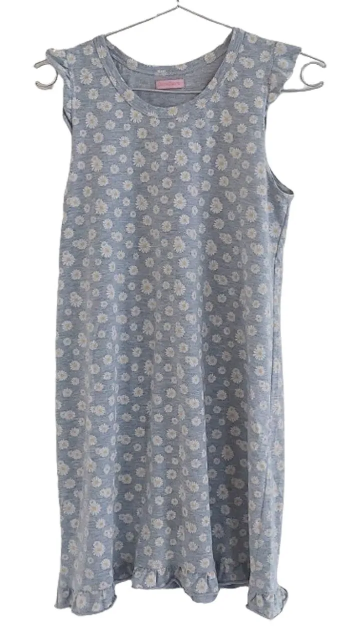 Vestido midi de mujer con estampado de flores blancas sobre fondo gris. Diseño sin mangas con volados en los hombros y en el ruedo. Ideal para un look fresco y casual.