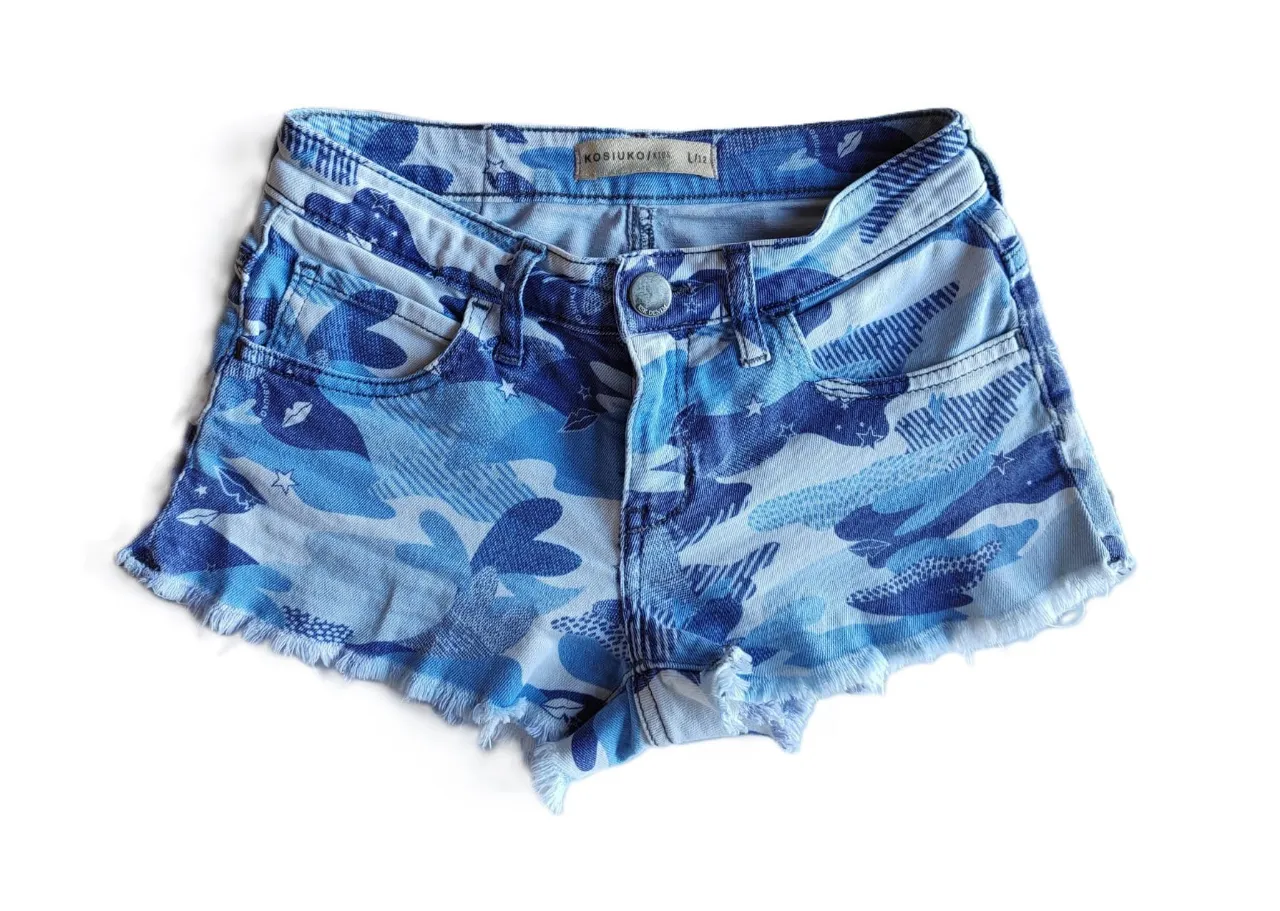 Short de jean de mujer con estampado camuflado en tonos azules y blancos. Tiro alto, con detalles de desgaste en los bordes. Ideal para un look casual y moderno.