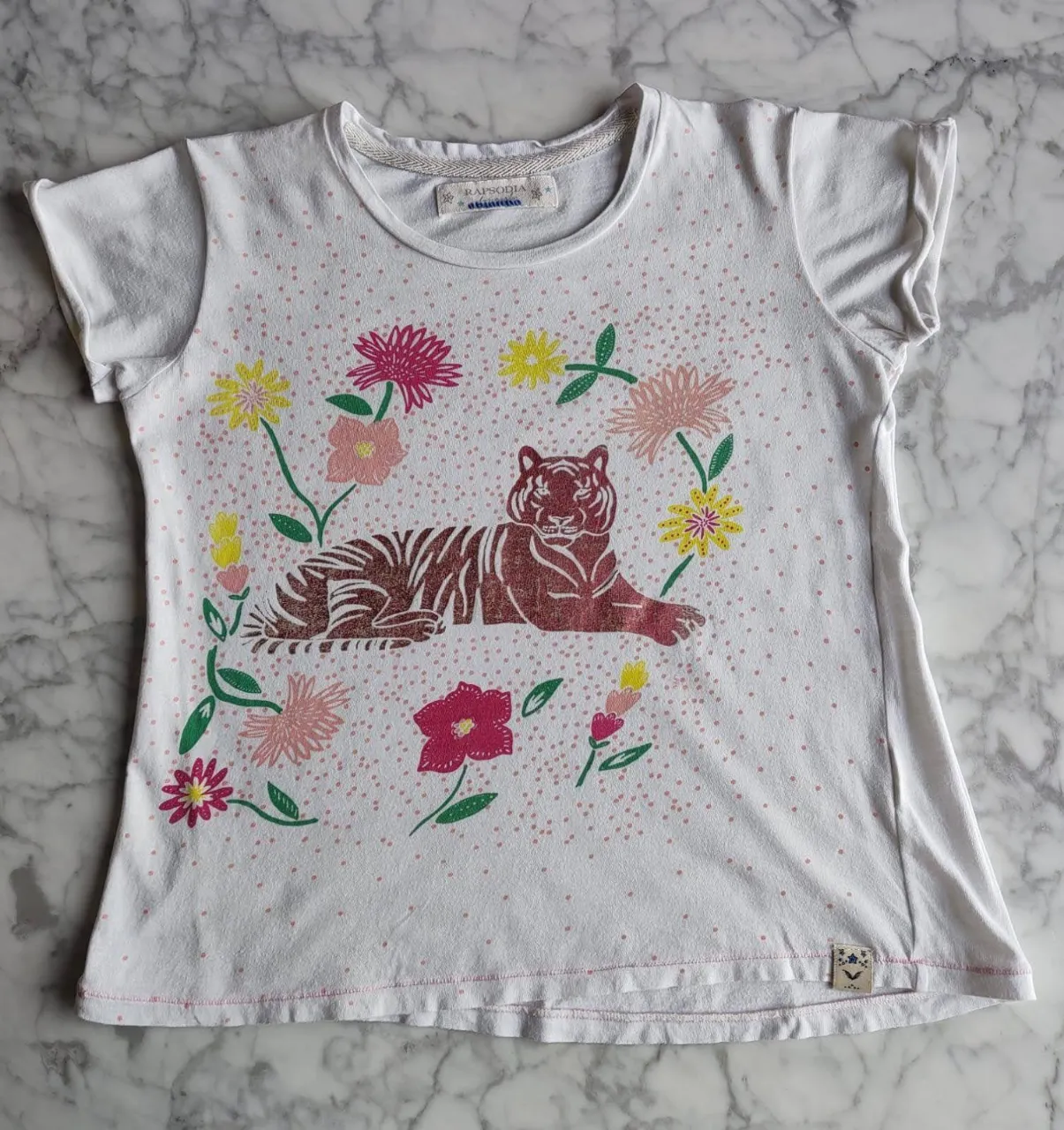 Remera blanca de niña con estampado de tigre y flores. Ideal para un look casual y cómodo.