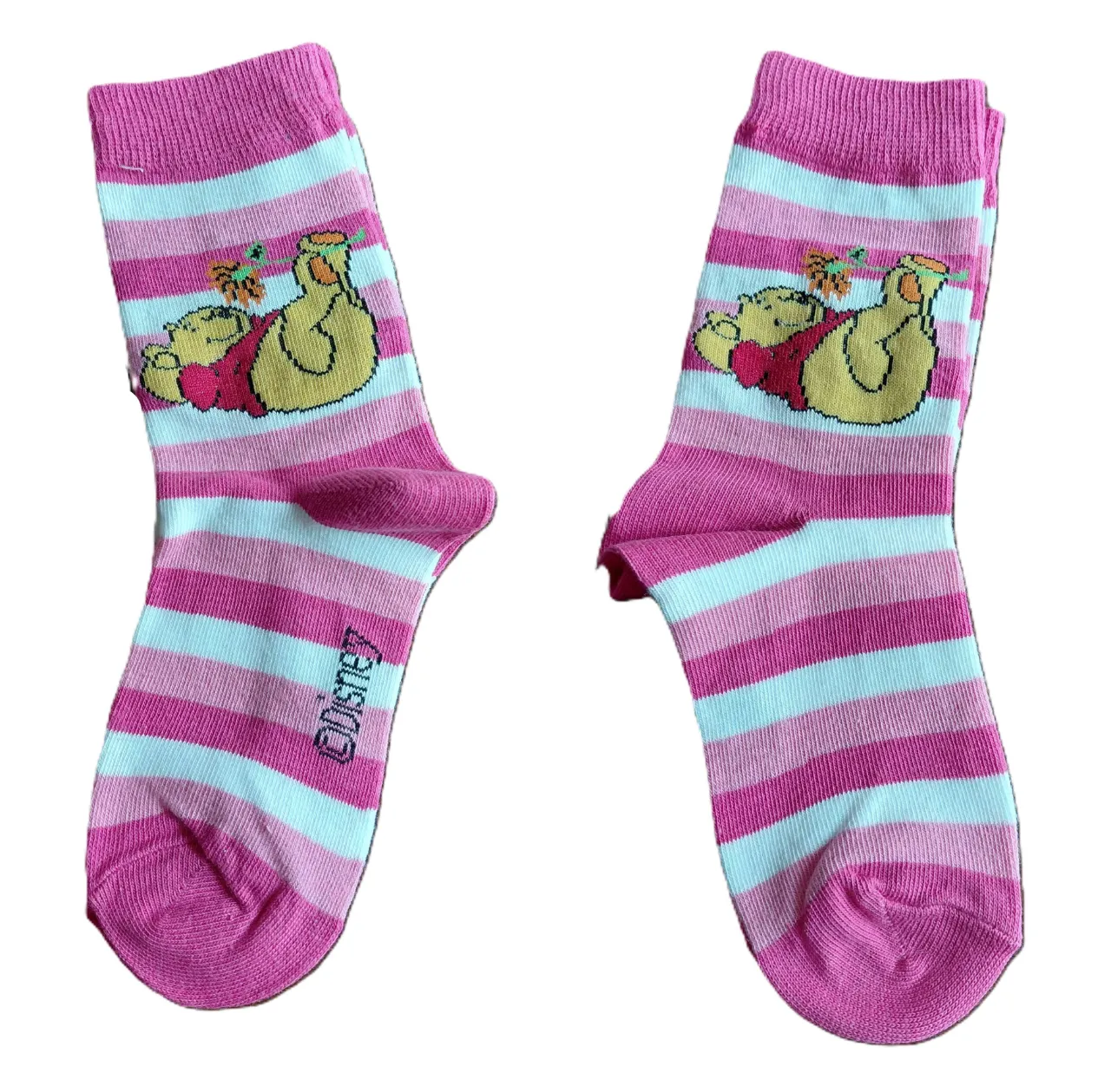 Par de medias de algodón con diseño de rayas rosas y blancas, y estampa de Pooh. El otro par es de medias de algodón con fondo azul y estampa de Tigger.