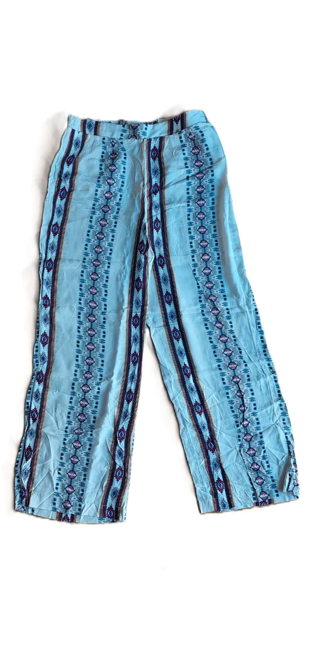 Pantalón palazzo estampado con franjas verticales en tonos celestes, rosas y azules. Ideal para un look boho o casual de verano.