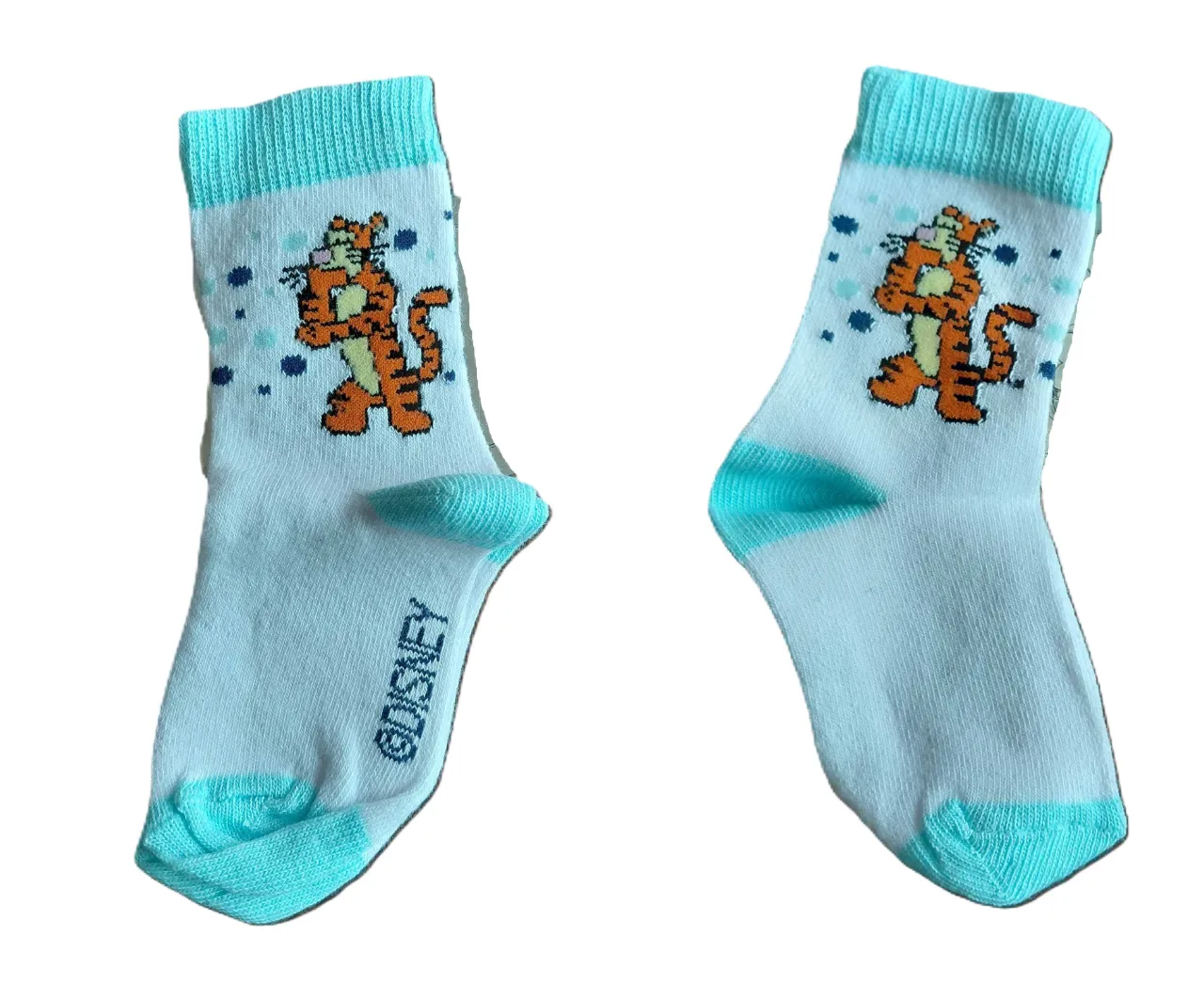 Par de medias de algodón con estampa de Tigger de Disney. El par de la izquierda es celeste con detalles en blanco y turquesa. El par de la derecha es turquesa con detalles en rosa.