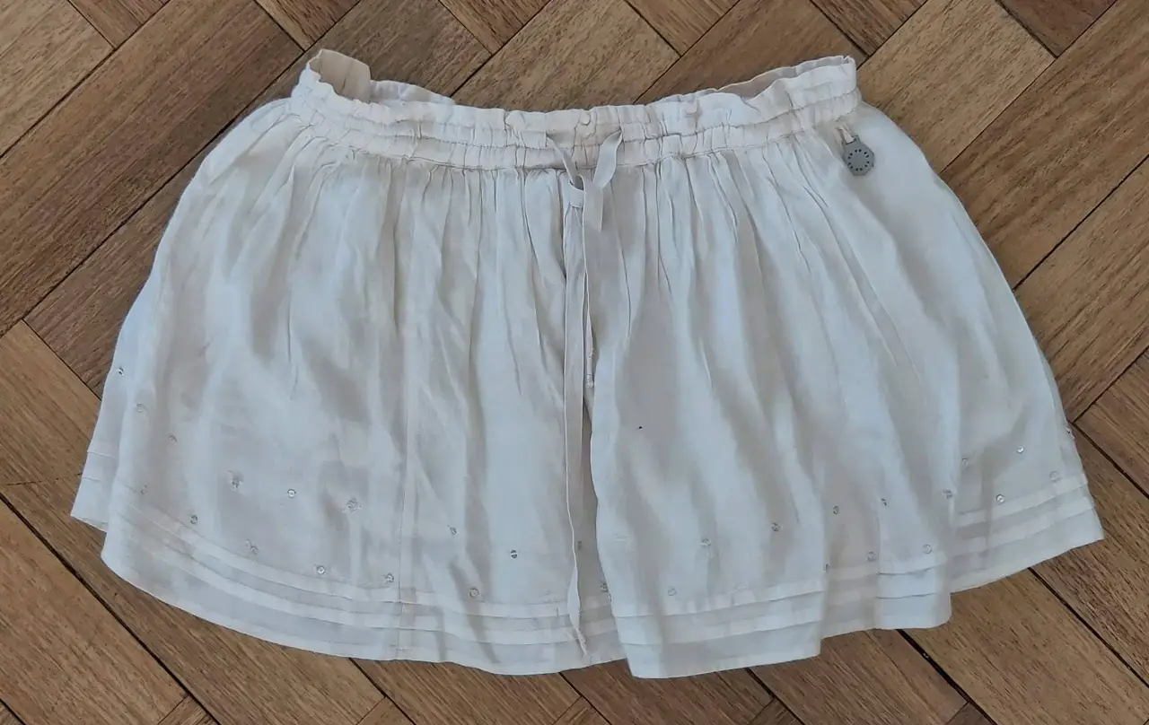 Pollera larga de niña, color blanco, con detalles de brillos. Ideal para un look fresco y cómodo.