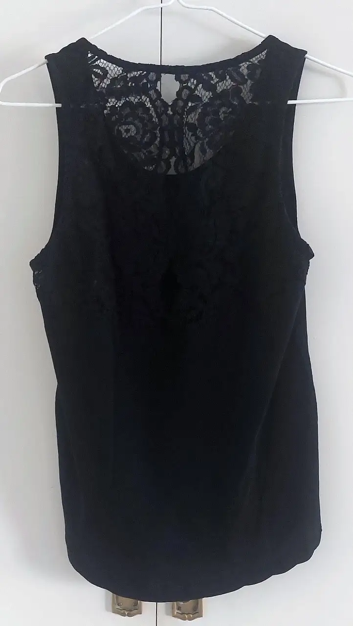 Musculosa negra con espalda de encaje, ideal para una salida casual o para combinar con un look más elegante. Marca Akiabara, talle 3.
