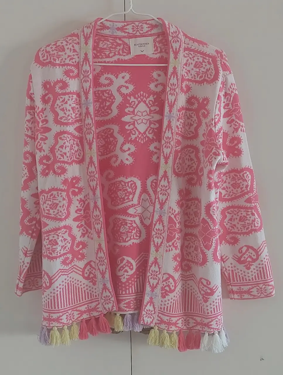 Cardigan de mujer con estampado floral en tonos rosa y blanco. Detalles de borlas en el bajo. Ideal para un look bohemio y casual.
