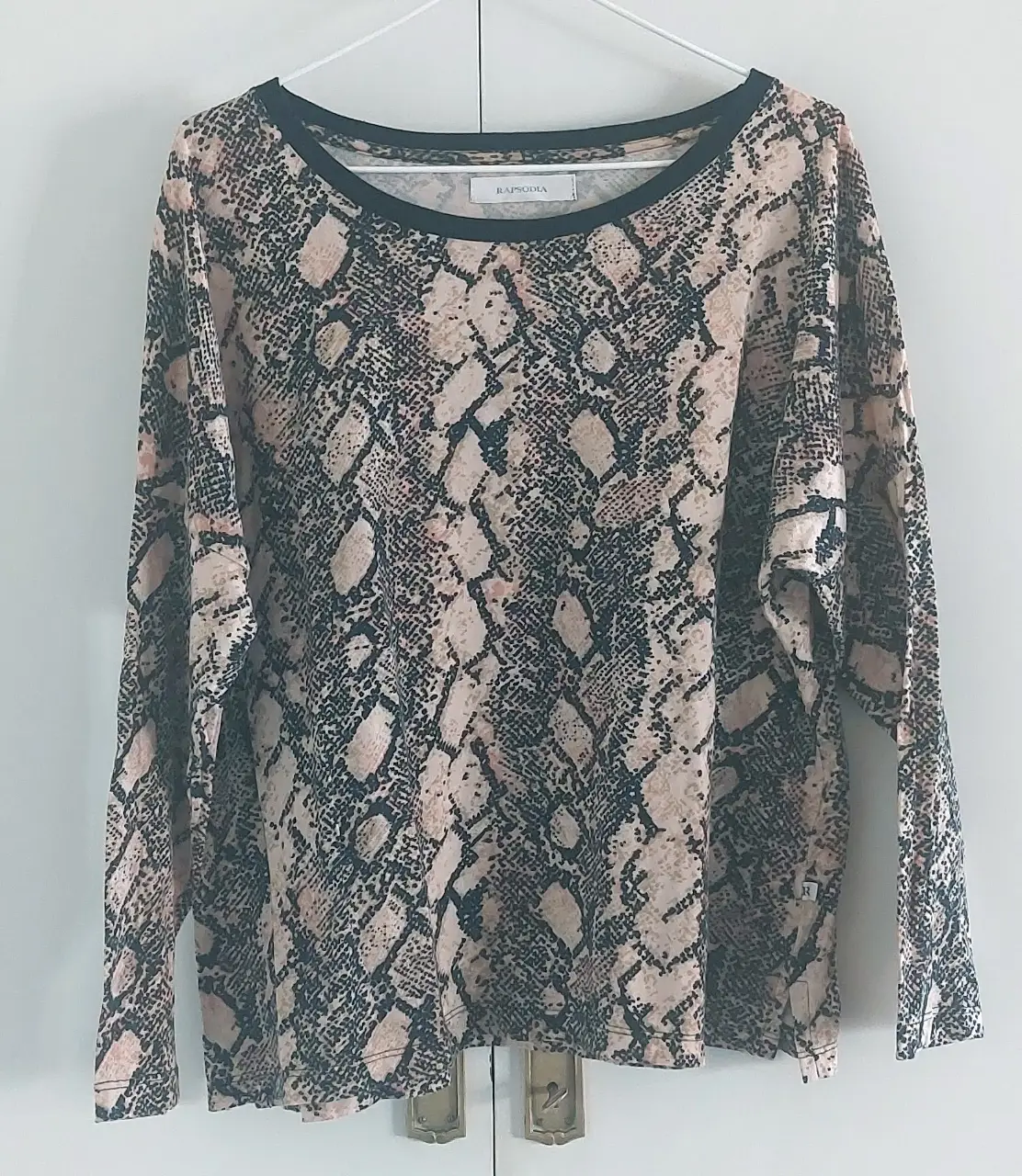 Remera de manga larga con estampado de serpiente en tonos nude y negro. Cuello redondo con detalle en negro. Ideal para un look casual y canchero.