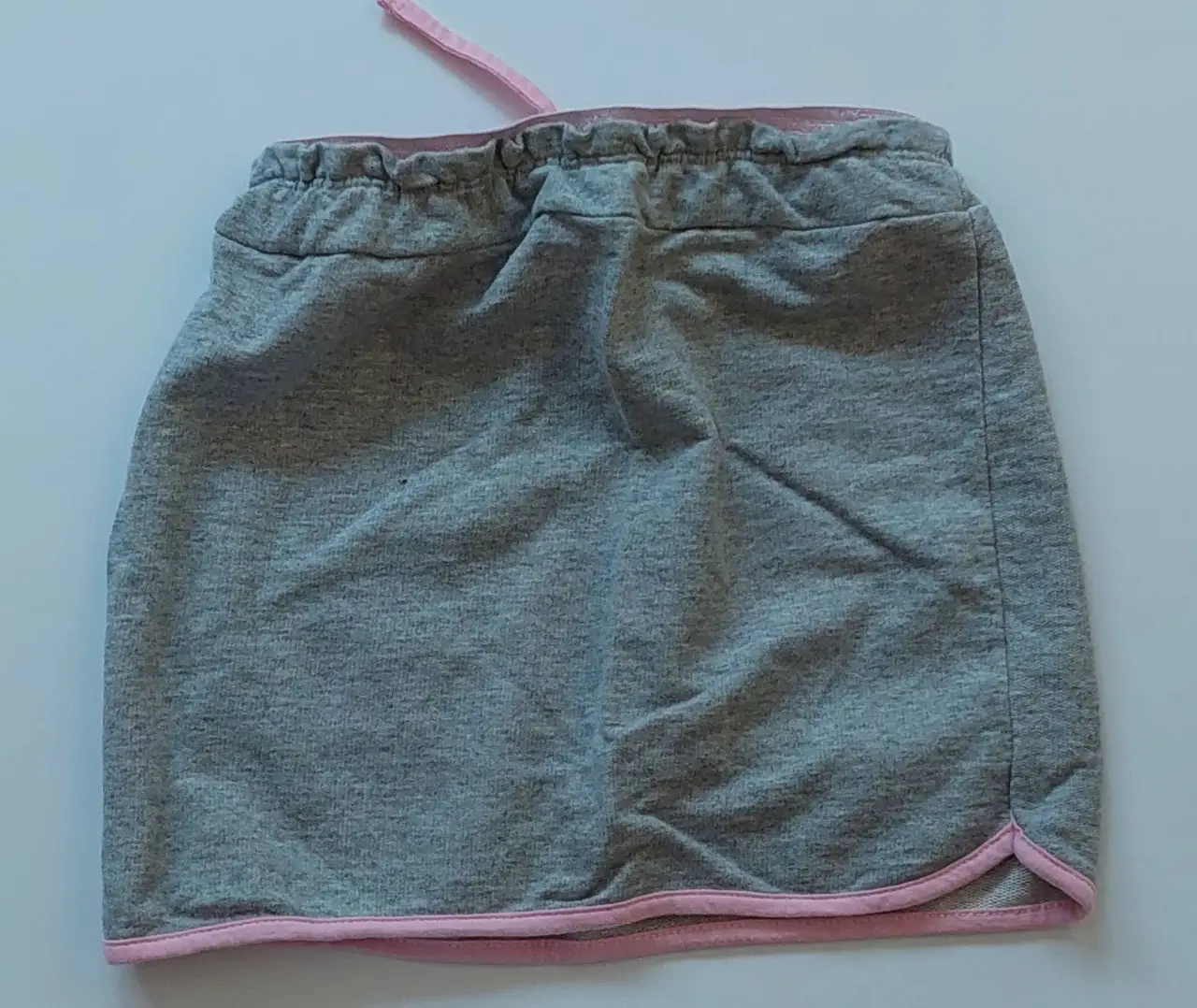 Pollera deportiva gris con detalles en rosa. Ideal para actividades físicas o un look casual y cómodo.